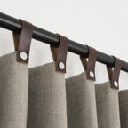 "Handcrafted chevron wool curtains with genuine leather snap button tabs, offering SPF 50+ protection, energy efficiency, and light control."