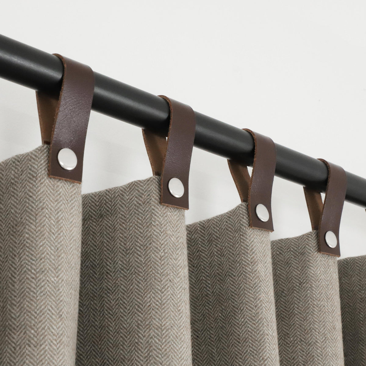 "Handcrafted chevron wool curtains with genuine leather snap button tabs, offering SPF 50+ protection, energy efficiency, and light control."