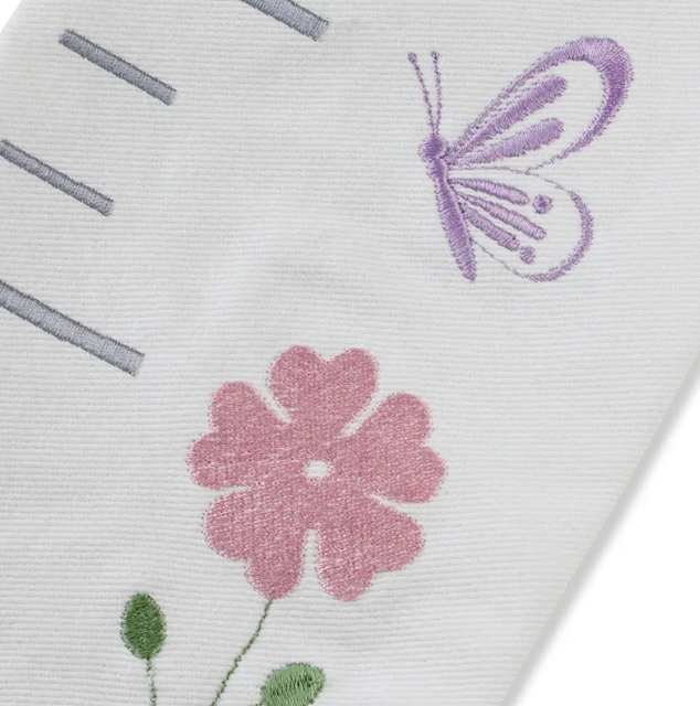 "Bespoke hand-embroidered cotton growth chart with delicate floral designs—durable, washable, and made to last."