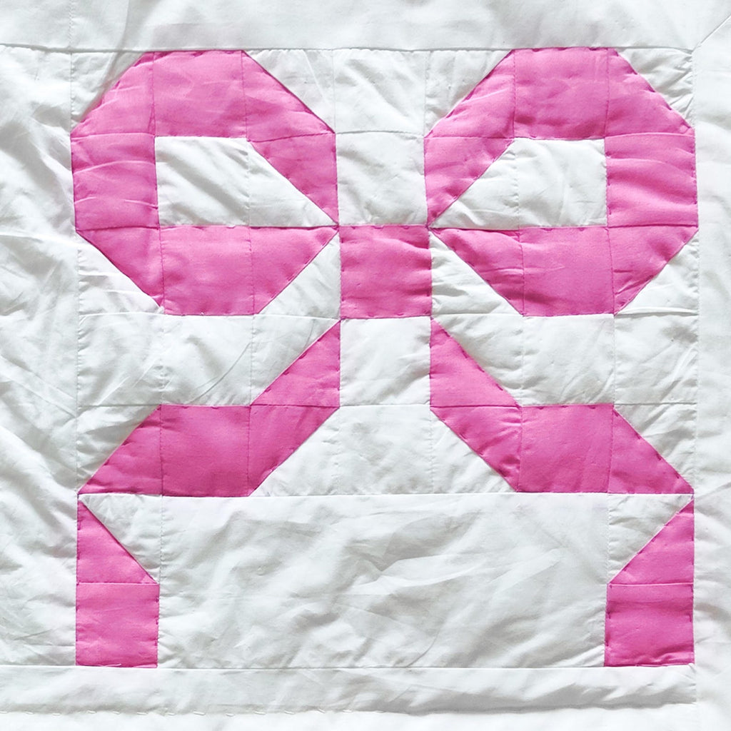 Machine washable handmade pink bow quilt in cotton patchwork. Available in multiple sizes for girls’ room and dorm décor.